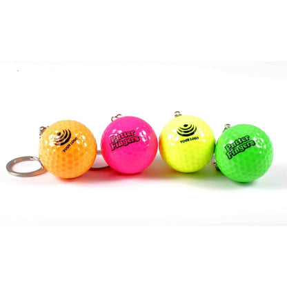 Four mini golf keyrings in vibrant orange, pink, green, and yellow. Two keyrings feature 'Your Logo' text (orange & yellow) with a generic logo, while the other two showcase the Putterfingers branding (pink & green)